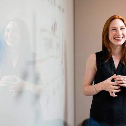 woman making checklist on whiteboard